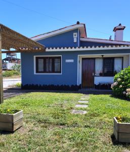a blue house with a lawn in front of it at BELACHA - Casa de Playa in Costa Azul