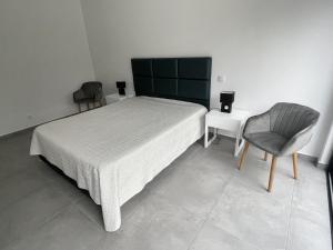 a bedroom with a bed and a chair at Villa Elodie Piscine privé, parking in Vau
