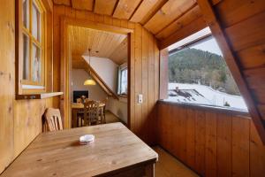 een eetkamer met een tafel en een groot raam bij Pension Vogtsmichelhof - Haupthaus in Alpirsbach