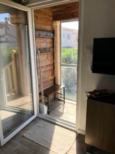 an open door to a balcony with a bench outside at Appart'Hotel au Pradet in Le Pradet