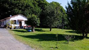 een klein huis in een tuin met bomen bij Gite Saint Pardoux L'ortigier in Saint-Pardoux-lʼOrtigier