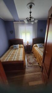 een slaapkamer met twee bedden en een raam bij Finca El Carbayal in El Campo