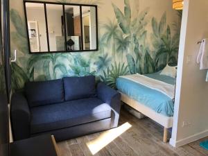 un salon avec un canapé et un miroir dans l'établissement Appart'Hotel au Pradet, au Pradet