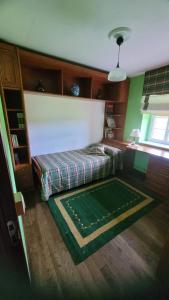 een slaapkamer met een bed en een groen kleed bij Finca El Carbayal in El Campo +30 foto's