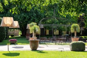 La Colombera Ristorante - Albergo في Castrezatto: حديقة بها حديقة بها أشجار نخيل