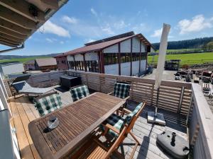een terras met een houten tafel en stoelen bij Hubertus in Dietingen