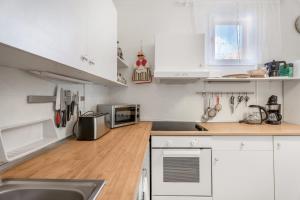 a kitchen with white cabinets and a wooden floor at Casa Con Vista in La Guancha
