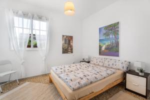 a white bedroom with a bed and a chair at Casa Con Vista in La Guancha