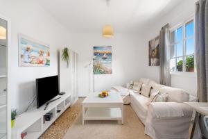 a white living room with a white couch and a tv at Casa Con Vista in La Guancha
