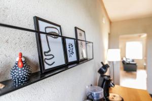 ein Regal an einer Wand mit Bildern darauf in der Unterkunft Lehmhuus in Klanxbüll + 21 Fotos