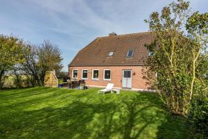 ein Backsteinhaus mit einer Bank im Hof in der Unterkunft Lehmhuus in Klanxbüll