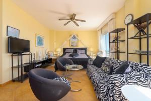 een woonkamer met een bank en een bed bij Villa Roca Penthouse in Estepona