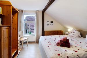 a bedroom with a bed with roses on it at Villa Harmonie - Apartment Jasmin in Borkum