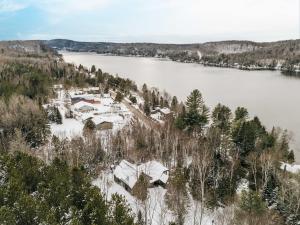 an aerial view of a house on the shore of a lake at Chalet Vintage with Private SPA & Sauna on the Lakeside in Labelle