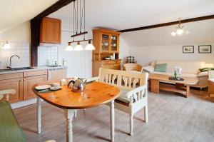 a kitchen and dining room with a wooden table at Villa Harmonie - Apartment Jasmin in Borkum