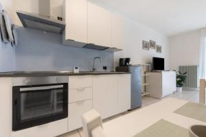 a kitchen with white cabinets and a stove at La casa di Romi in Mori