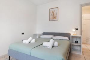 a white bedroom with a bed with white pillows at La casa di Romi in Mori