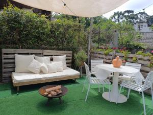 a patio with a bed and a table and chairs at Chalé Elohim Campos do Jordão in Campos do Jordão