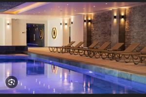 a pool in a hotel with lounge chairs next to it at Caesar Resort SPA in Iskele +8 photos