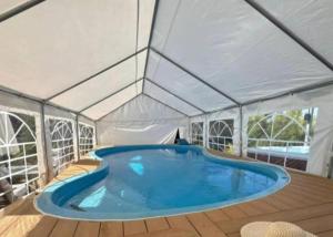 ein großes Schwimmbecken in einem Zelt in der Unterkunft לה פטלונה - ווילה מהממת עם בריכה פרטית מחוממת ומקורה בכפר ורדים in Kefar Weradim