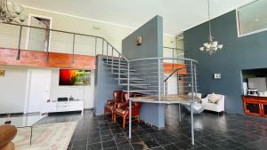a spiral staircase in a living room with a table at Royal Guesthouse The Castle in Mtunzini