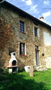 Ca' Rionda - Antica Casa Rurale في Osiglia: مبنى حجري امامه فرن طوب