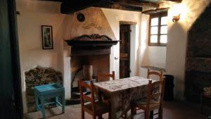 Ca' Rionda - Antica Casa Rurale في Osiglia: غرفة طعام مع طاولة ومدفأة