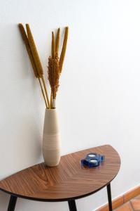 a white vase sitting on a wooden table with sticks at Casa Oceano-Ave do Mar in Raposeira