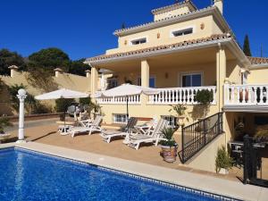 una villa con piscina di fronte a una casa di Villa Roca a Estepona