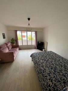 een slaapkamer met een bed en een bank bij Grand Studio avec loggia in Thorigny-sur-Marne