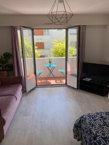 een woonkamer met een bank en een balkon bij Grand Studio avec loggia in Thorigny-sur-Marne