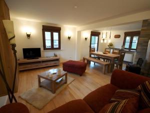 a living room with a couch and a tv and a table at Ferienhaus Paula in Langenbrand