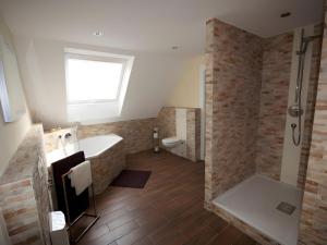 a bathroom with a shower and a tub and a toilet at Ferienhaus Paula in Langenbrand +26 photos