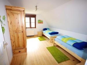 two beds in a room with green rugs at Ferienhaus Paula in Langenbrand