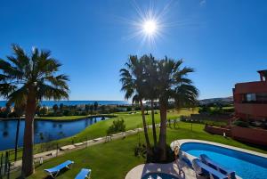 a view of a resort with a pool and palm trees at El Patio de Doña Julia in Bahia de Casares