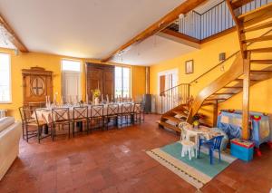 een eetkamer met een tafel en stoelen en een trap bij Les oiseaux in Louvemont