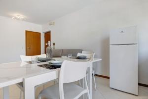 una cucina bianca con tavolo bianco e sedie bianche di Appartamento Cuore di Comano a Comano Terme