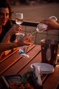 two people are pouring wine into glasses on a table at Tsauchab River Camp in Sesriem