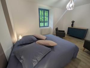 een slaapkamer met een bed met kussens en een raam bij Le nancery in Langres
