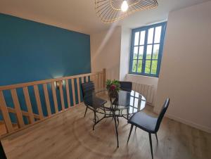 een eetkamer met een glazen tafel en stoelen bij Le nancery in Langres