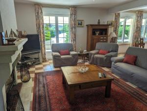 ein Wohnzimmer mit zwei Sofas und einem Couchtisch in der Unterkunft Au fil de l'eau in Louvemont