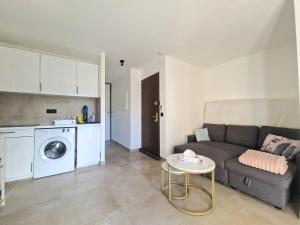 ein Wohnzimmer mit Sofa und Tisch in der Unterkunft Coquet 2 pièces neuf Calvi Plage in Calvi + 8 Fotos