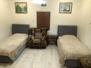 a room with two beds and a chair in it at Sweet house in Gyumri
