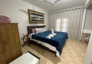 Un dormitorio con una cama con una manta azul. en Hotel e Pousada Ciconha-são Lourenço MG, en São Lourenço 46 fotos más