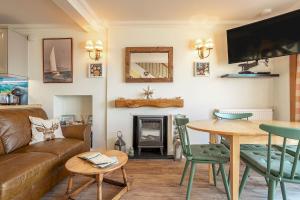 uma sala de estar com um sofá e uma mesa em Rockhopper Cottage Lower Largo em Lower Largo