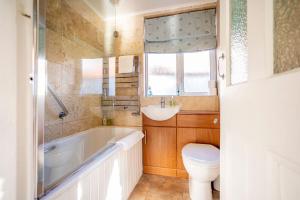 um banheiro com banheira, vaso sanitário e pia em Rockhopper Cottage Lower Largo em Lower Largo mais 49 fotografias