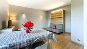 uma sala com uma mesa com flores vermelhas em El Refugio Sujadaro em Osséja