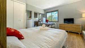 um quarto com uma grande cama branca e uma televisão em El Refugio Sujadaro em Osséja