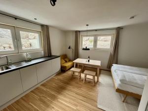 Una habitación con una cocina, una mesa y un sofá. en Ferienwohnung Bergufer - Studio im Souterrain, en Oberammergau