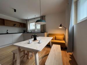 una sala de estar con una mesa y un sofá en Ferienwohnung Bergufer - Studio im Souterrain, en Oberammergau